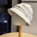 Detail view of the elegant beige pleated bucket hat, showcasing unique short brim style. - Adult Adjustable 54-60 / Beige