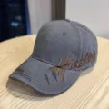 Close-up detail of the vintage distressed baseball cap featuring brown embroidery and grey fabric. - Adult 54-60 Adjustable / Gray