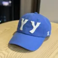 Close-up detail of the blue baseball cap with white 3D embroidered YY letters and side logo. - Blue