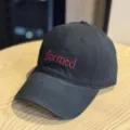 Closeup of black embroidered baseball hat with red formed lettering detail product. - Black