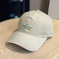Detailed view of the beige baseball cap with green embroidered lettering on the crown. - Adult 54-60 Adjustable / Khaki