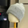 Primo piano del berretto in maglia grigia con dettagli di strass e perle, design caldo. - Taglia Unica Adulto 54-60cm / Grigio