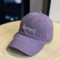 Close-up detail shot of a stylish purple baseball cap featuring white embroidered lettering. - Purple