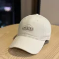 Close-up detail of the beige baseball cap showing front CARE embroidery and fine stitching. - Adult 54-60 Adjustable / Beige