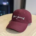 Detailed view of the burgundy baseball cap featuring white cursive New York embroidery. - Adult 54-60 Adjustable / Burgundy