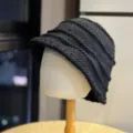 Detail view of the dark grey knit bucket hat, showcasing unique wrinkled texture and warm yarn. - Adult 54-60 Average Size / Black