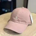 Close-up of pink cotton baseball cap featuring front white letter embroidery and side white tag. - Adult 54-60 Adjustable / Pink