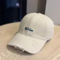 Beige distressed baseball cap with blue embroidered cursive text, soft top casual hat. - Adult 54-60 Adjustable / Beige