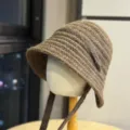 Nahaufnahme der kuscheligen Strick-Wintermütze mit Ohrenklappen in braunem Garn. - Erwachsene 54-60 Einheitsgröße / Kaffeebraun