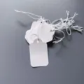 Blank white paper hang tags with elastic strings, perfect for DIY labeling and pricing items. - 2.5x4cm / White