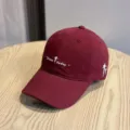 Primo piano dei dettagli del cappellino bordeaux con ricamo Strive today e stella bianca. - Borgogna
