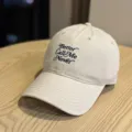 Detailansicht der beigen Baseballkappe mit dunkler Schreibschriften-Bestickung und breiter Krempe. - Erwachsene 54-60 Einstellbar / Beige