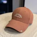 Detail view of a vintage brown baseball cap featuring front california dreaming white embroidery text. - Adult 54-60 Adjustable / Orange
