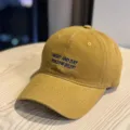 Detailed shot of washed distressed retro baseball cap with front embroidery, casual unisex hat. - Adult 54-60 Adjustable / Caramel color
