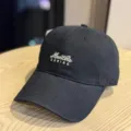 Details of the black washed cotton baseball cap with stylish embroidered lettering design. - Adult 54-60 Adjustable / Black