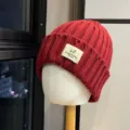 Detailed shot of a red knitted beanie with a cute sheep logo patch for winter warmth. - Adult One Size (54-60cm) / Burgundy