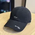 Detailed view of the black baseball cap showing the embroidered letters and curved brim. - Adult 54-60 Adjustable / Black