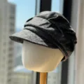 Vista detallada de la gorra de mezcla de lana gris con pliegues elegantes y visera. - Negro