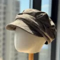 Vista detallada de una gorra de tweed marrón, sombrero estilo pintor retro con pliegues. - Caqui