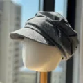 Primer plano detalle gorra de tweed gris, sombrero octogonal vintage sobre maniquí. - Gris