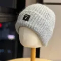 Close-up detail view of gray knitted beanie hat featuring metal patch and pearl decor. - Adult One Size (54-60cm) / Light Gray