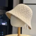 Detailed view of the cozy knitted bucket hat showcasing the delicate crochet pattern and cute bow. - Khaki