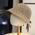 Brown knit bucket hat detail showcasing textured wool fabric and cute back bow ribbon. - Coffee