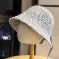Primo piano di un cappello bucket in maglia soffice grigia con grazioso nastro sul retro. - Grigio