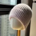 Primo piano dettagliato della morbida trama in maglia rosa del caldo berretto invernale. - Taglia Unica Adulto (54-60cm) / Rosa