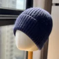 Primo piano dettaglio di un berretto invernale in maglia a costole blu scuro e morbido. - Taglia Unica Adulto (54-60cm) / Blu navy