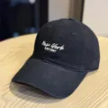 Close-up detail of black cotton baseball cap with white New York embroidery on wood surface. - Adult 54-60 Adjustable / Black