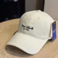 Close-up detail of beige baseball cap with black New York embroidery and side hangtag. - Adult 54-60 Adjustable / Beige