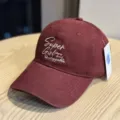 Close-up detail of the burgundy baseball cap featuring stylish white embroidered text on front. - Adult 54-60 Adjustable / Burgundy