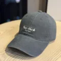 Close-up detail of a dark grey washed baseball hat featuring white embroidered text on the front. - Adult 54-60 Adjustable / Dark Gray