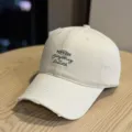 Casual beige baseball cap with distressed brim and embroidered front lettering for daily wear. - Adult 54-60 Adjustable / Beige
