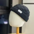 Gedetailleerd aanzicht van de donkergrijze gebreide muts, met een minimalistisch ontwerp. - Volwassen 54-60 Verstelbaar / Zwart