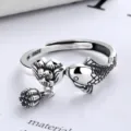 Exquisite detail shot of a retro silver lotus and koi ring with a dangling seed pod charm. - Adjustable Open Design / Silver