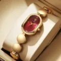 Élégante montre quartz ovale pour femme avec cadran bordeaux et bracelet doré détail. - Rouge Or