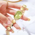 Détail de montre quartz ovale dorée, cadran vert, élégant bracelet montre femme chic. - Or et Vert