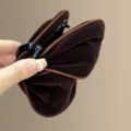 Detaillierte Nahaufnahme der braunen Samt Haarkralle mit weicher Textur und starkem Griff. - Dunkelbraun