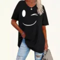Λεπτομερής όψη του μαύρου κοντομάνικου t-shirt με ένα χαριτωμένο χαμόγελο που κλείνει το μάτι. - S / Tops / Μαύρο
