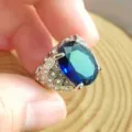 Primo piano dettagliato di un elegante anello da uomo con pietra blu e zirconi pavé. - Anello di Zaffiro Rettangolare / Blu scuro