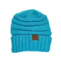 Close-up detail of the bright blue knitted beanie featuring a brown leather patch and ribbed cuff design. - One Size / Sky Blue