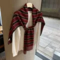 Primer plano detallado del elegante chal de punto a rayas superpuesto sobre jersey blanco. - 170x53cm / Marrón Rojizo