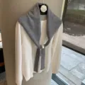 Detailed view of layered grey knit scarf shawl paired with white sweater, soft texture. - One Size / Gray
