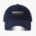 Nahaufnahme der dunkelblauen Baseballkappe mit gestickten Herzen und inspirierendem Text. - Verstellbar / Marineblau