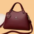 Élégant sac à main en cuir bordeaux avec bandoulière et joli charm pour les femmes - Rouge