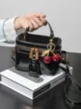 Sac bandoulière vanity en cuir verni noir avec charm cerise, sac à main élégant pour femme. - Noir