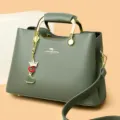 Stijlvolle groene dames schoudertas met handvat, chic metaal en leuke bedel hanger. - Groen
