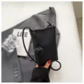 Minimalistische zwarte mini crossbodytas van zacht leer met chique knoopriem voor dames. - Zwart